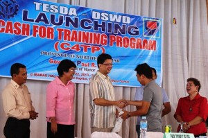 TESDA Regional Director Cleta Omega (second from L), Northern Samar Provincial Governor Paul Daza (third from L) and DSWD Assistant Regional Director for Administration, Virginia Idano (in red) and other officials, help distribute the training vouchers to the youths involved in the program.