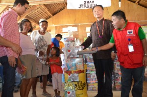 Ambassador Zhao gives out food packs to a family in the Cali Transitional Shelter.  Looking on are DSWD Assistant Regional Director Resty Macuto and Tacloban Vice-Mayor Jerry Sambo Yaokasin