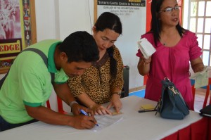 CSAP beneficiary signs distribution sheet acknowledging recipt of check for the construction of his house.